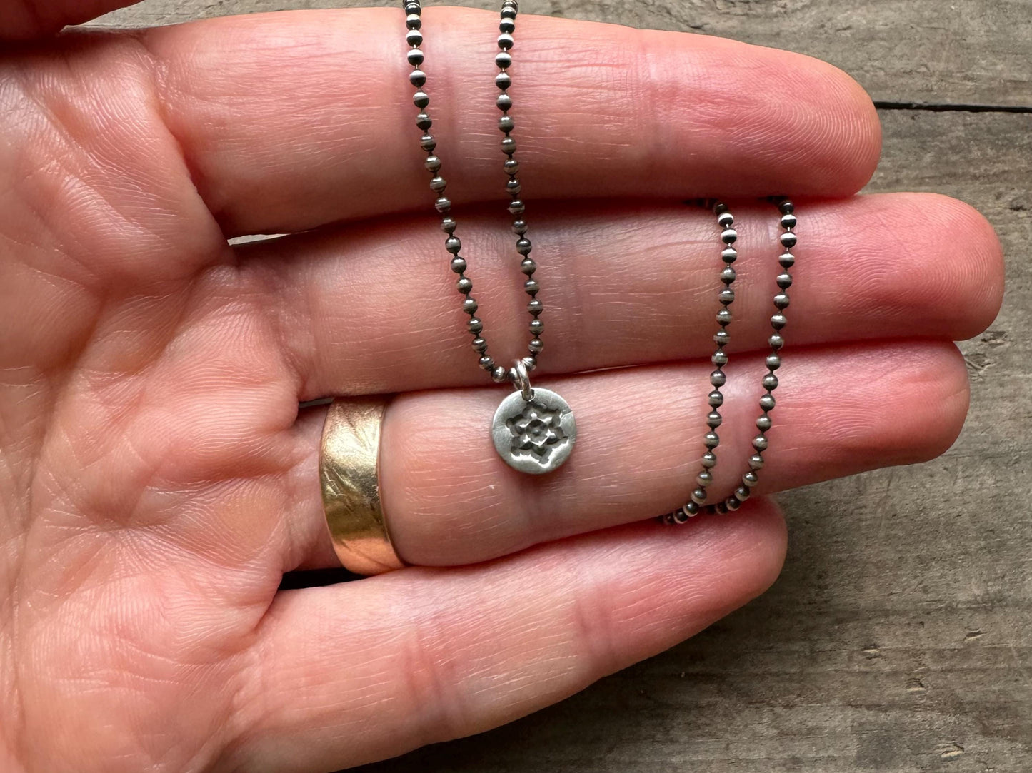 Tiny stamped flower necklace in oxidized sterling silver