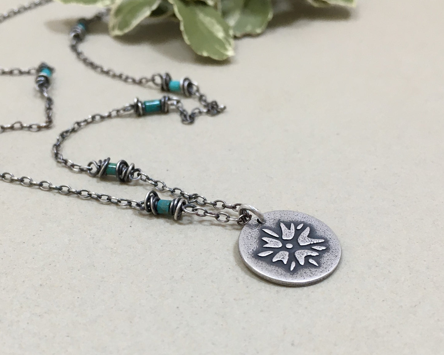 Silver flower charm on turquoise beaded chain