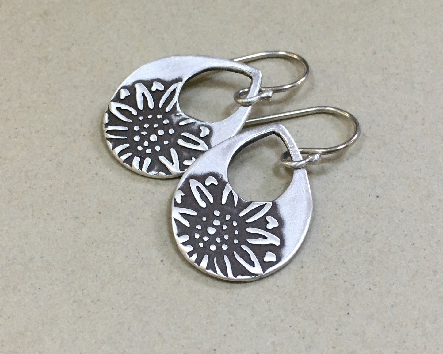 Silver teardrop earrings with sunflower design