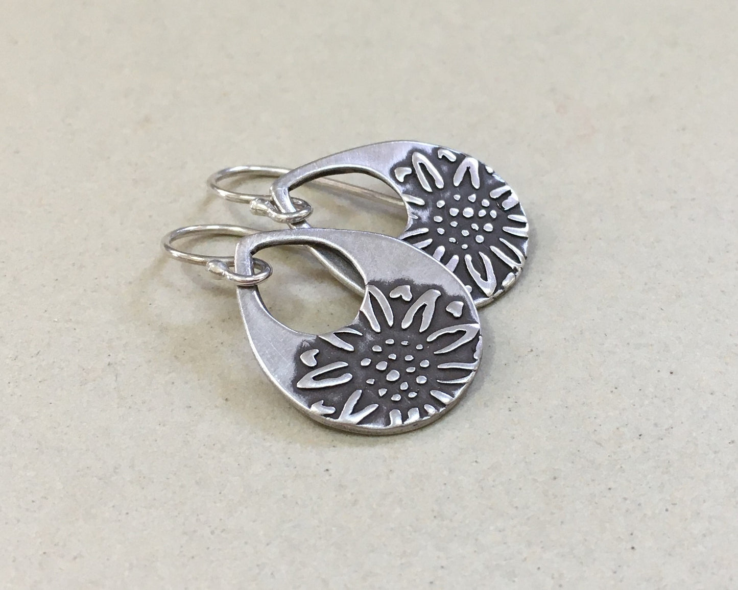 Silver teardrop earrings with sunflower design