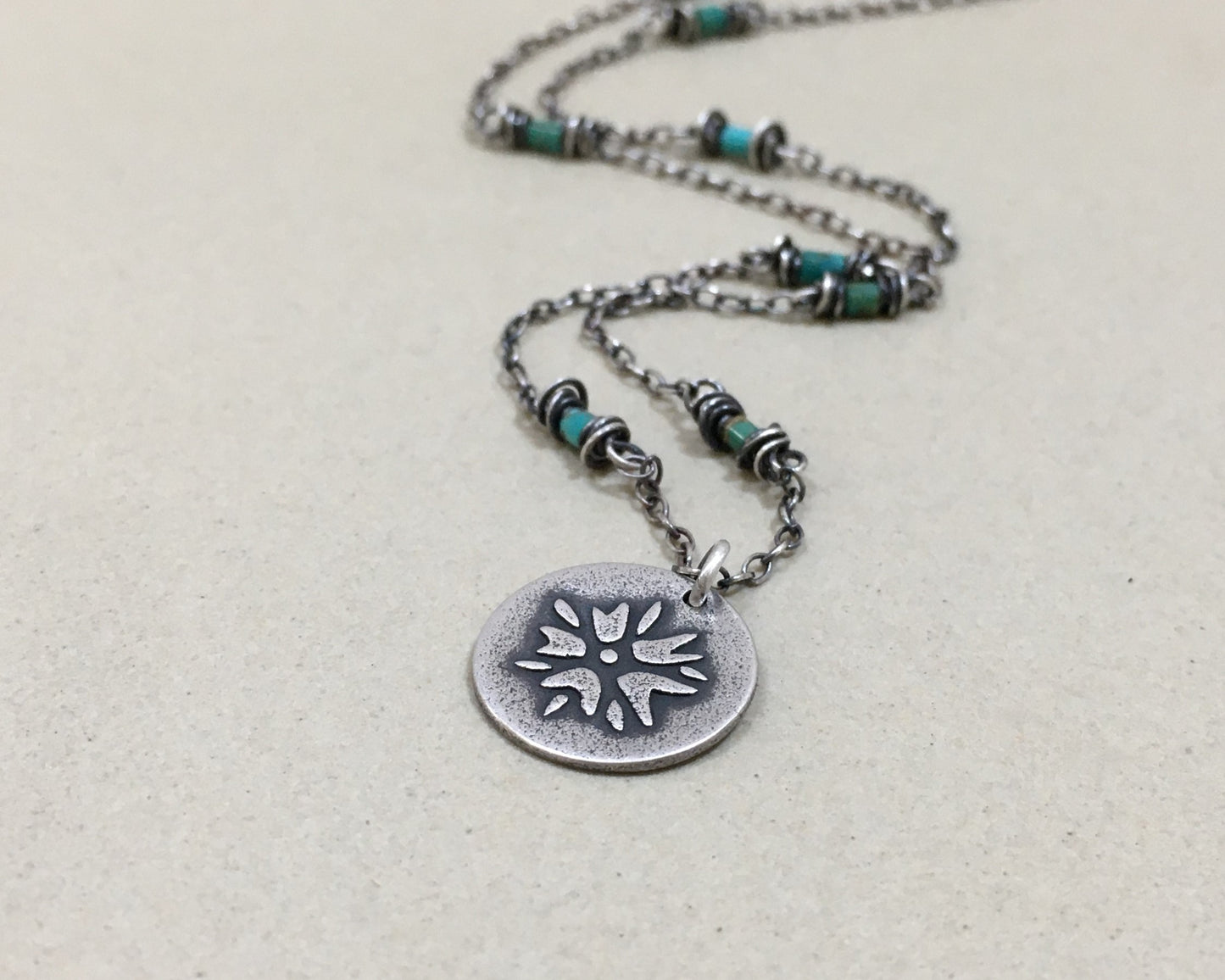 Silver flower charm on turquoise beaded chain