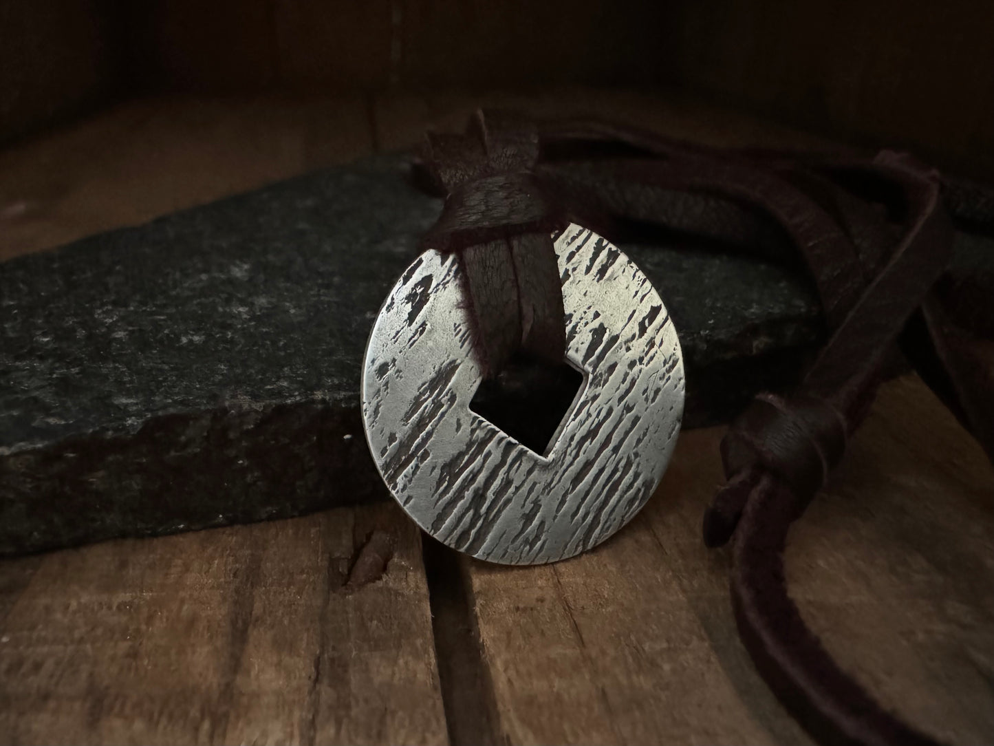 Rustic silver wood grain pendant on adjustable leather lace