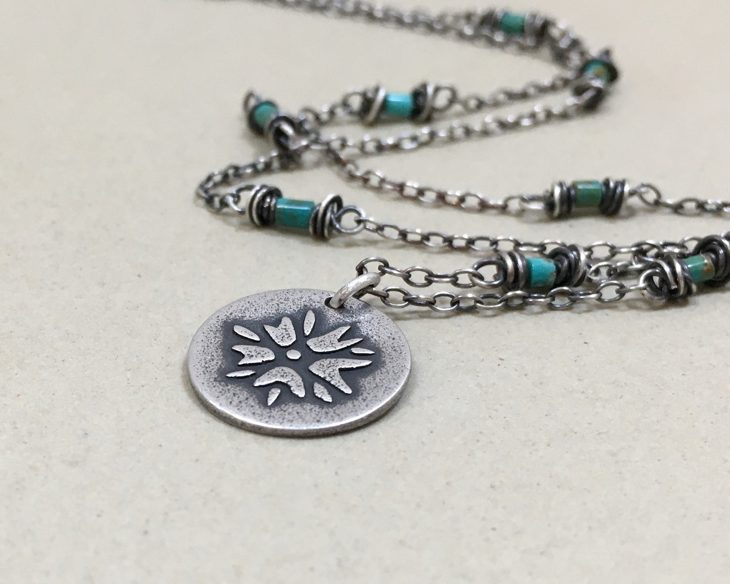 Silver flower charm on turquoise beaded chain