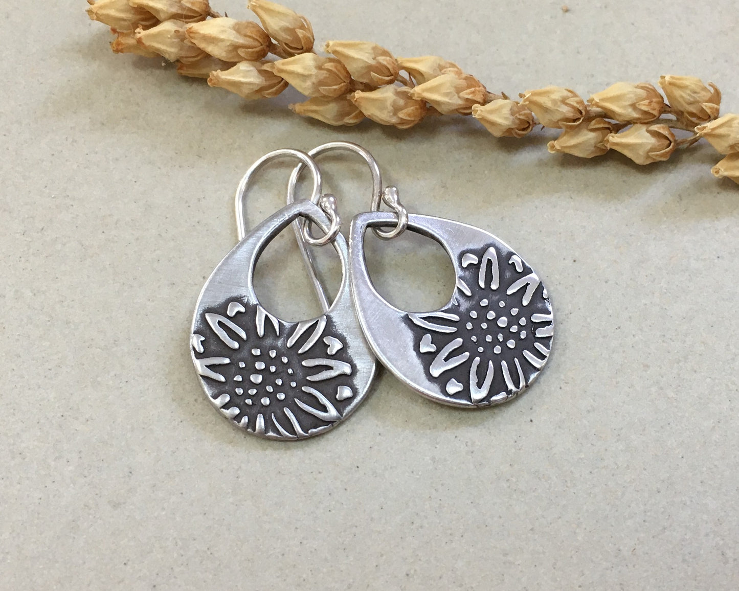 Silver teardrop earrings with sunflower design