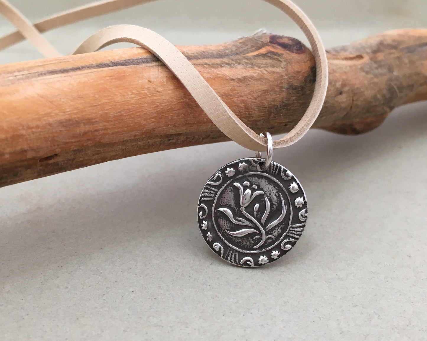 Silver floral medallion on soft leather lace