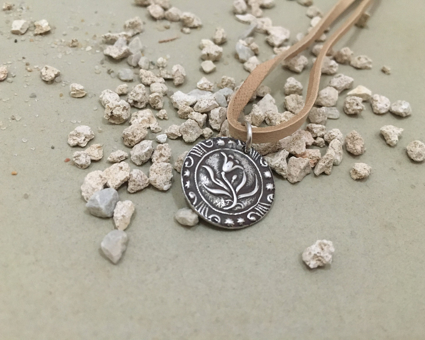Silver floral medallion on soft leather lace