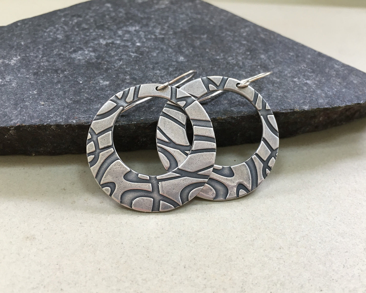 Stylized swirly hoops in oxidized sterling silver