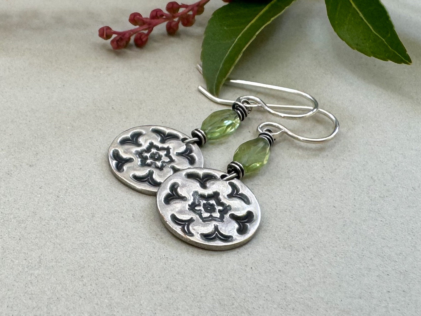 Silver stamped flower earrings with green peridot