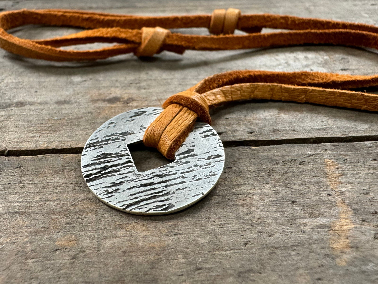 Rustic silver wood grain pendant on adjustable leather lace