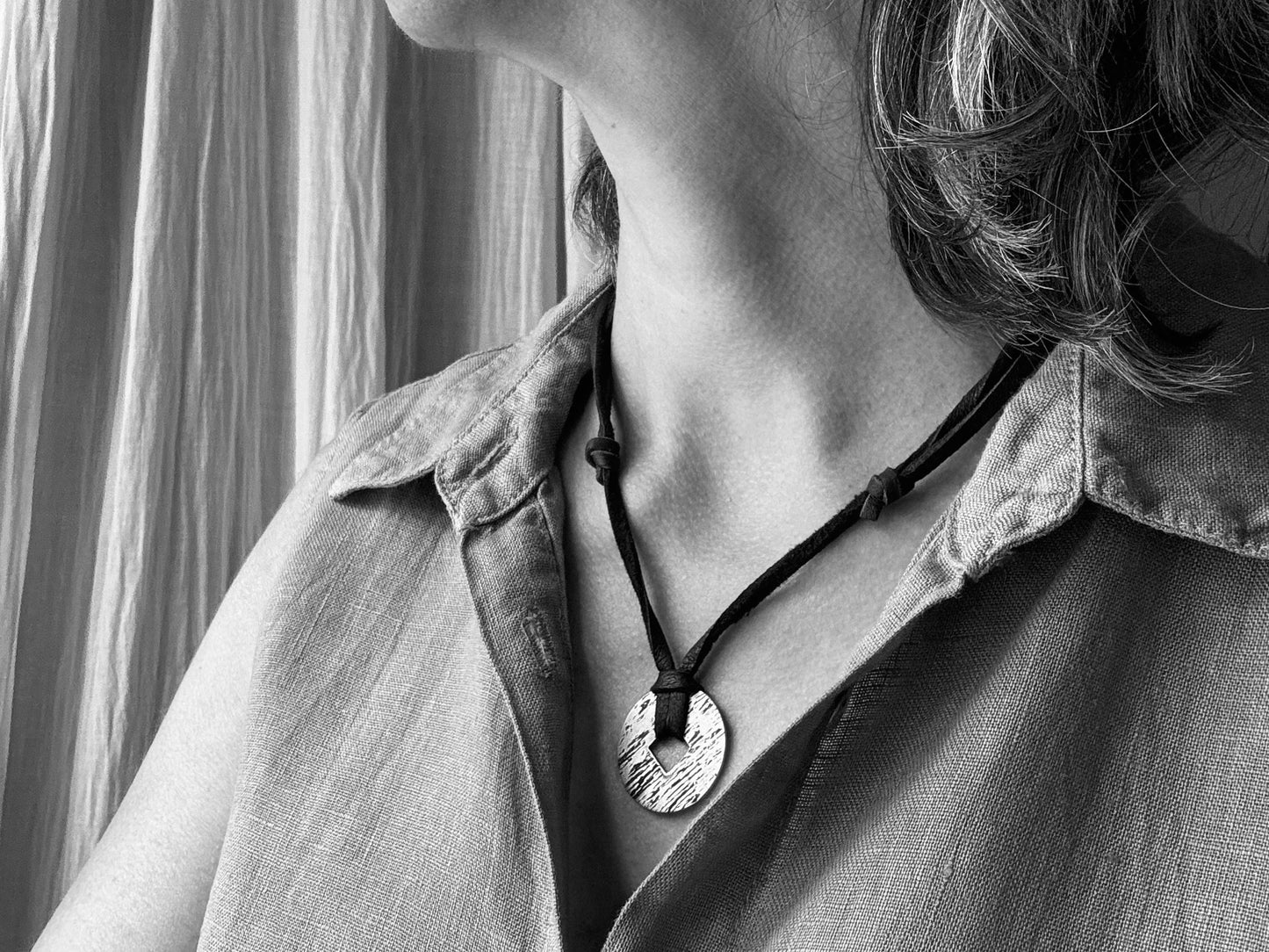 Rustic silver wood grain pendant on adjustable leather lace