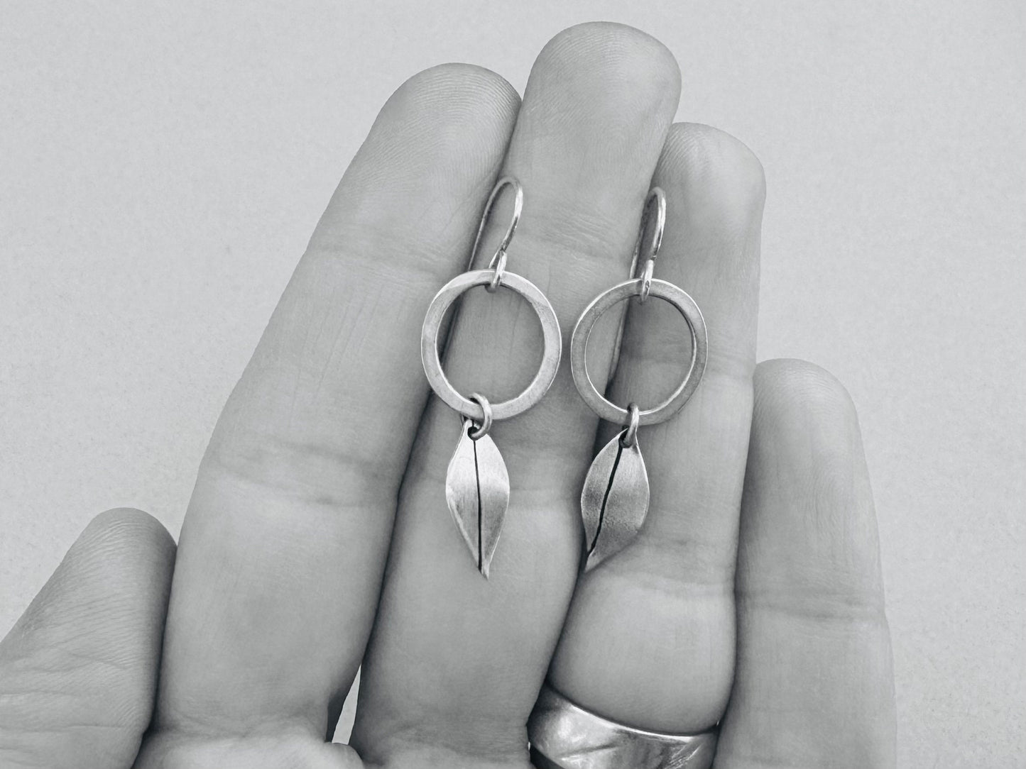 Little silver hoops with simple leaves in a brushed satin finish