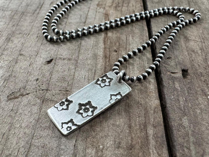 Silver stamped flower dog tag necklace
