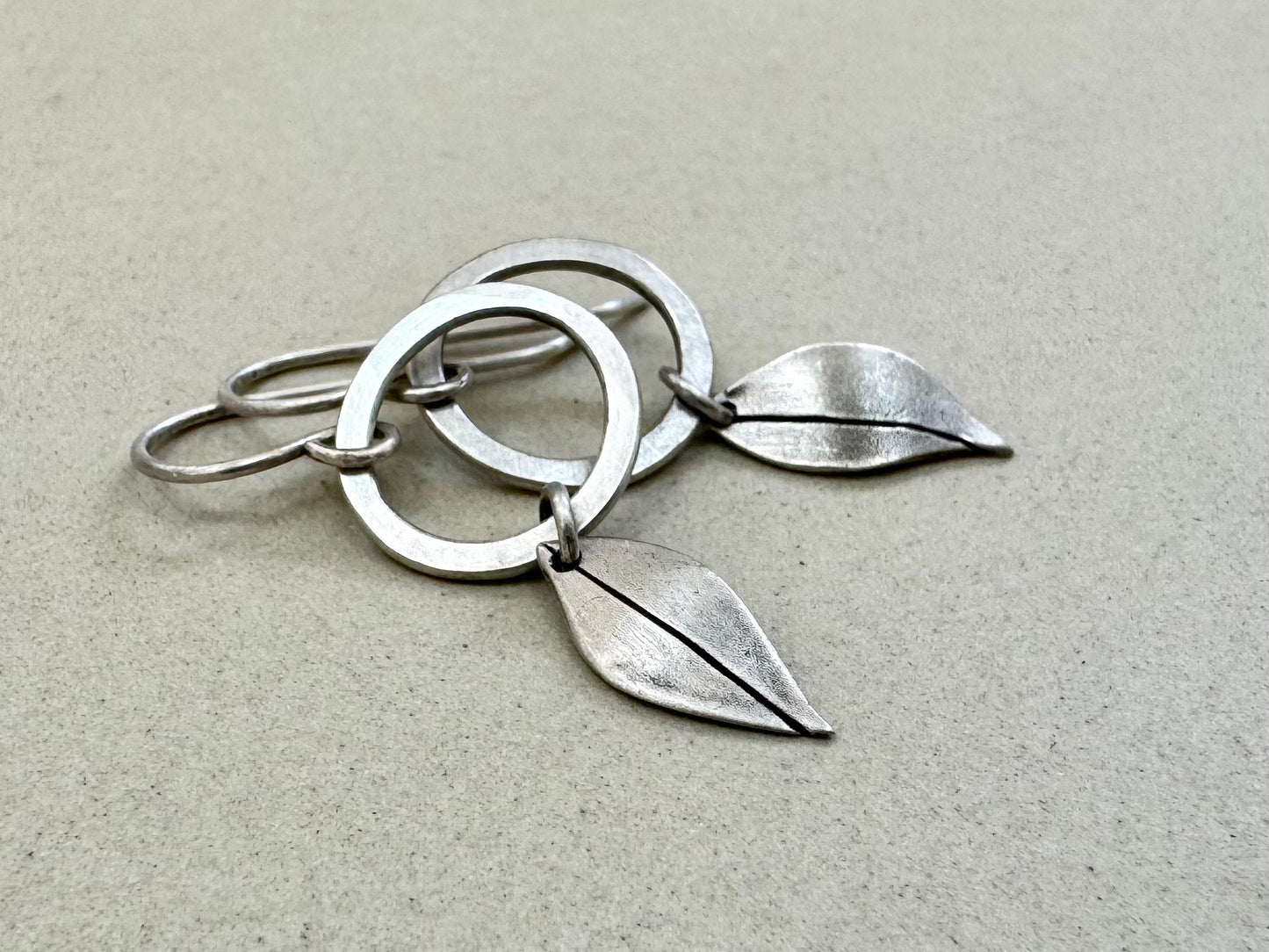 Little silver hoops with simple leaves in a brushed satin finish