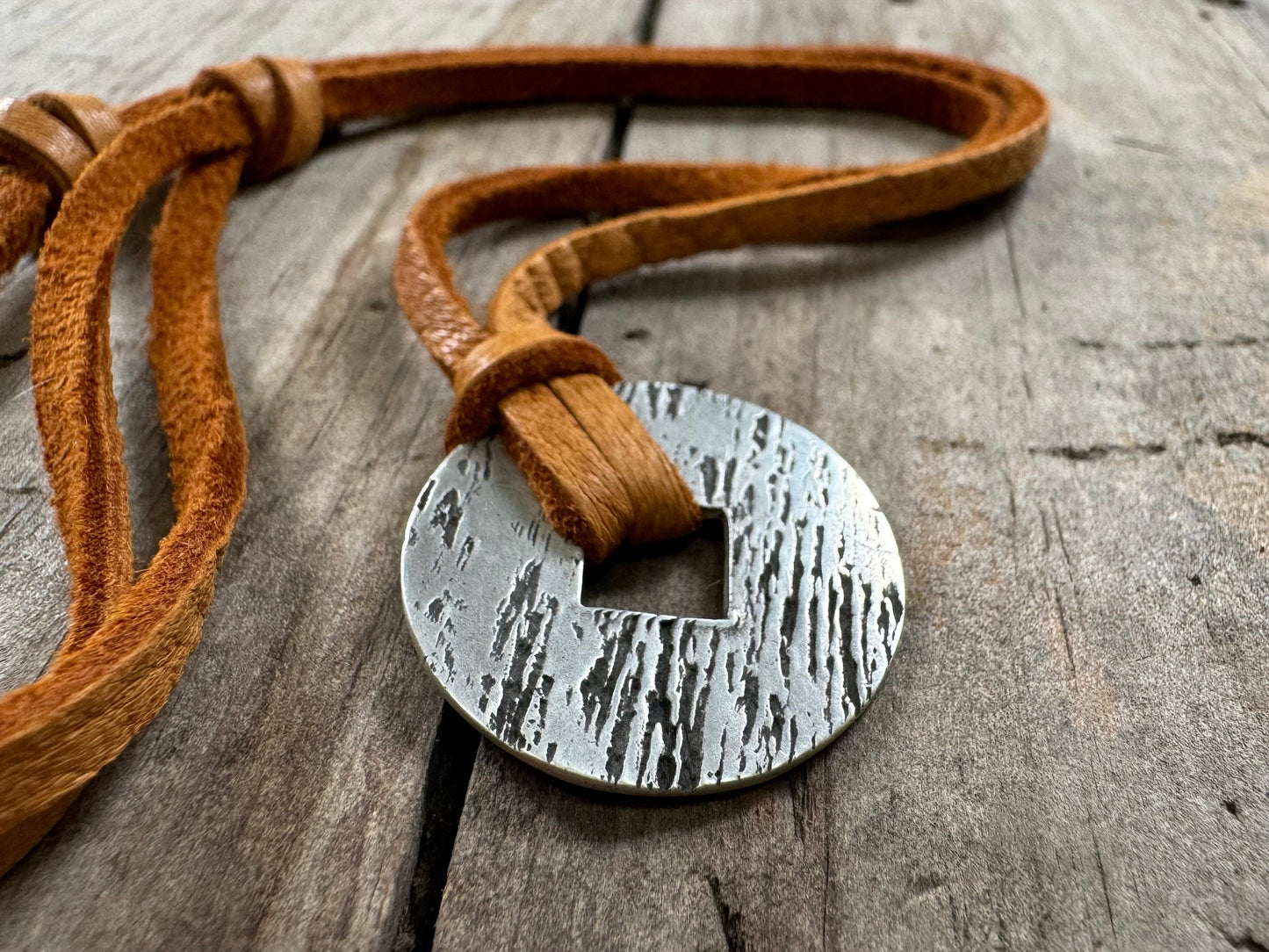 Rustic silver wood grain pendant on adjustable leather lace