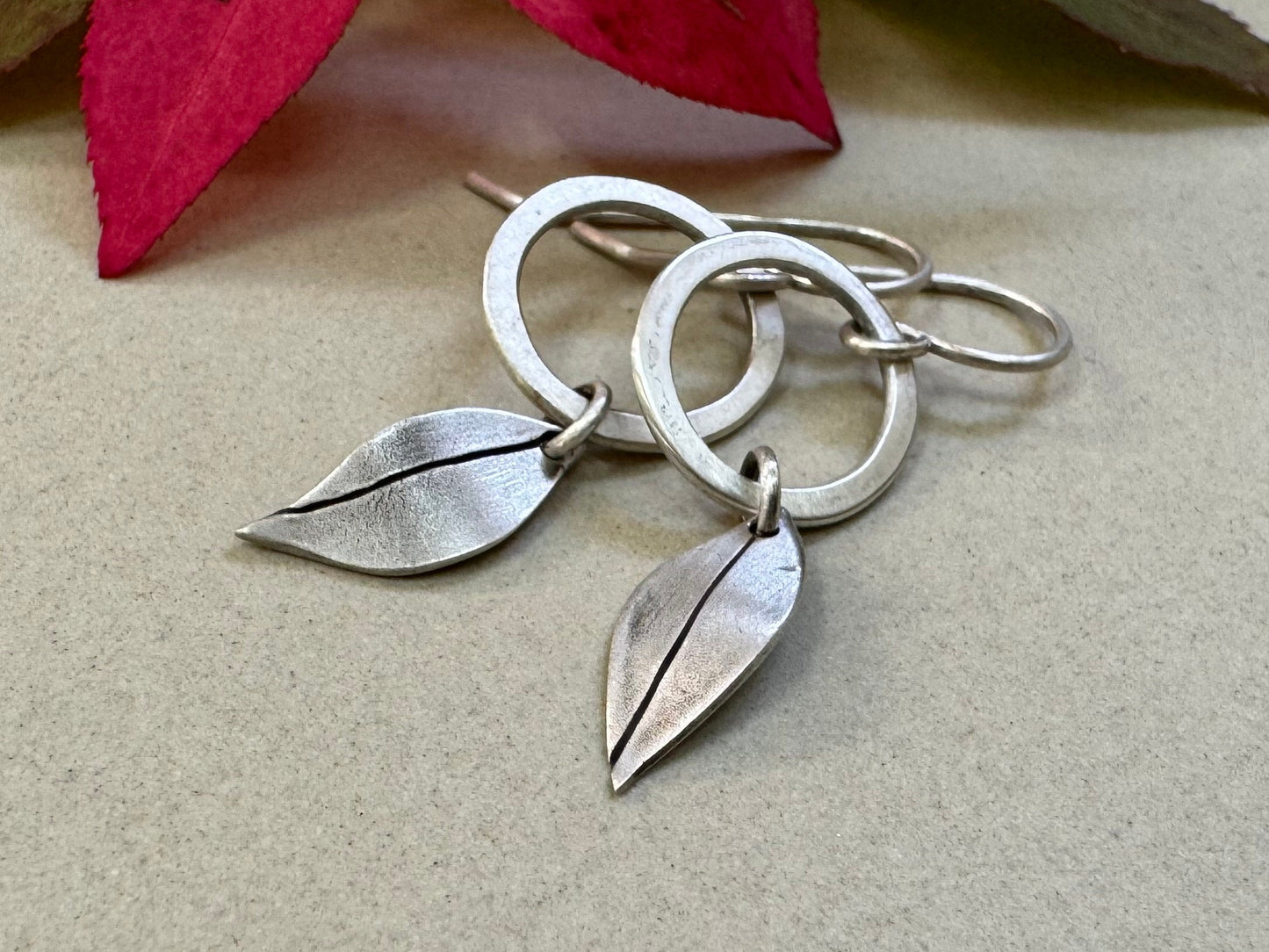 Little silver hoops with simple leaves in a brushed satin finish