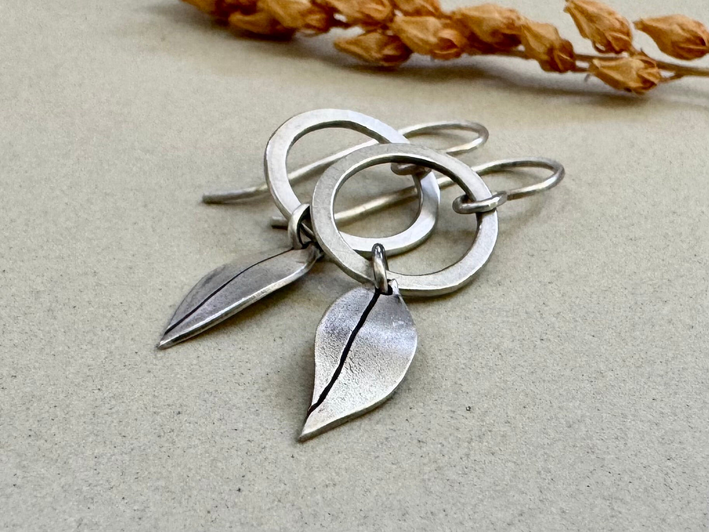 Little silver hoops with simple leaves in a brushed satin finish