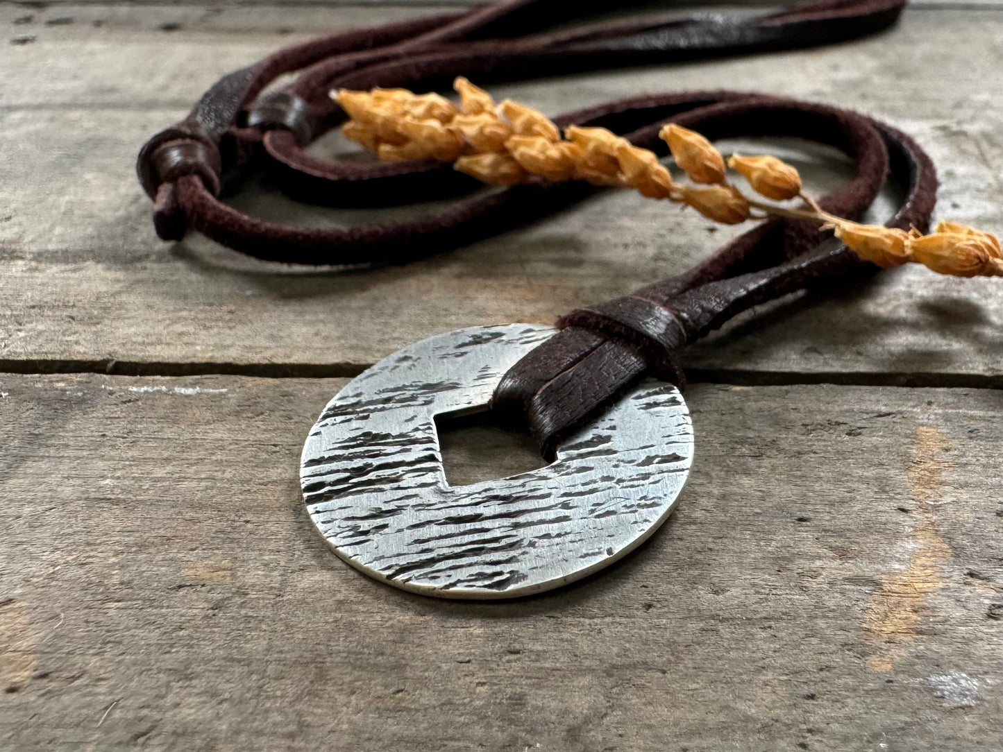 Rustic silver wood grain pendant on adjustable leather lace