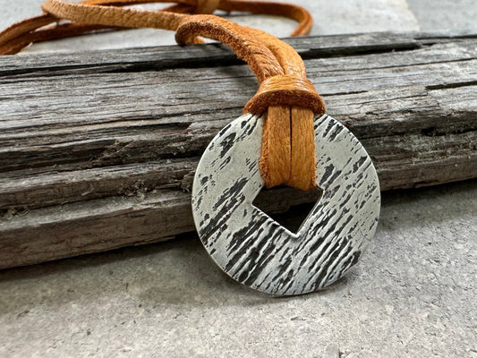 Rustic silver wood grain pendant on adjustable leather lace