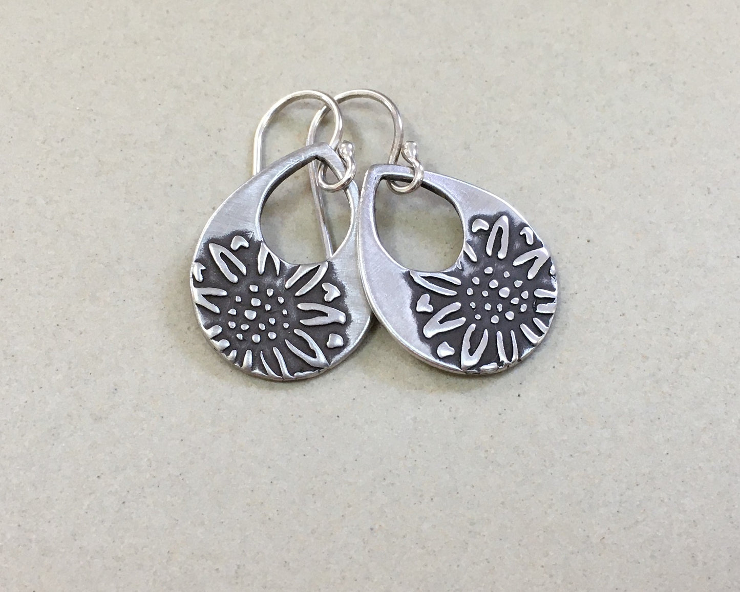 Silver teardrop earrings with sunflower design