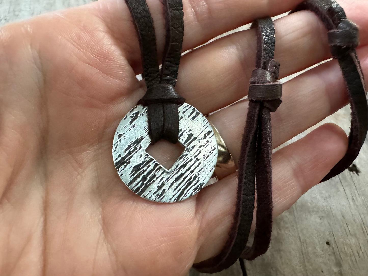Rustic silver wood grain pendant on adjustable leather lace