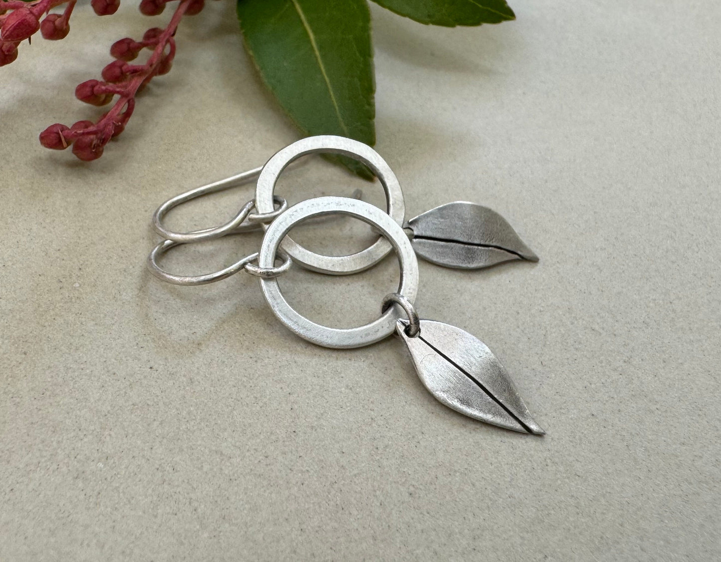 Little silver hoops with simple leaves in a brushed satin finish