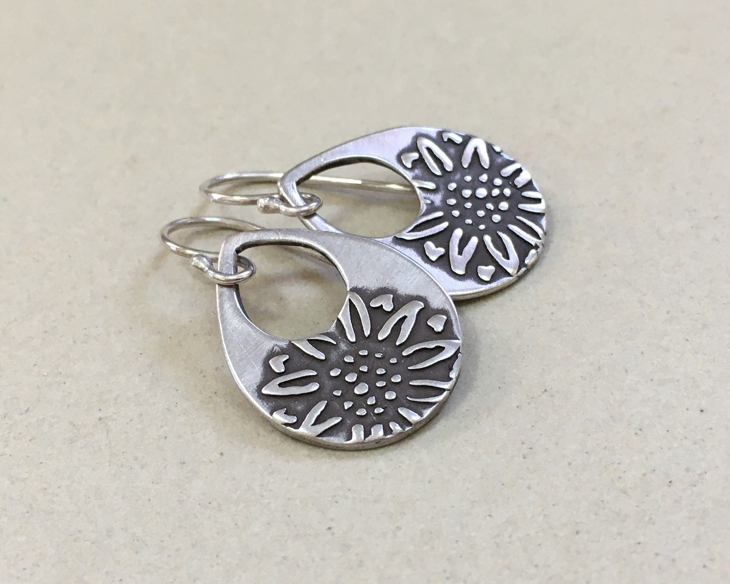 Silver teardrop earrings with sunflower design