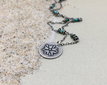 Silver flower charm on turquoise beaded chain