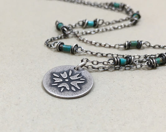 Silver flower charm on turquoise beaded chain