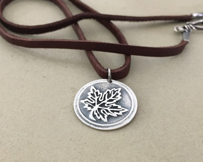 Silver maple leaf pendant on leather