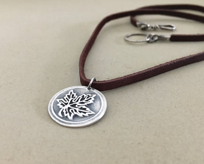Silver maple leaf pendant on leather