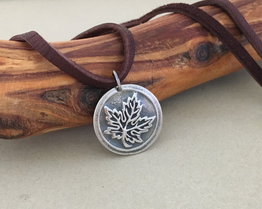 Silver maple leaf pendant on leather