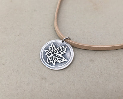 Silver maple leaf pendant on leather