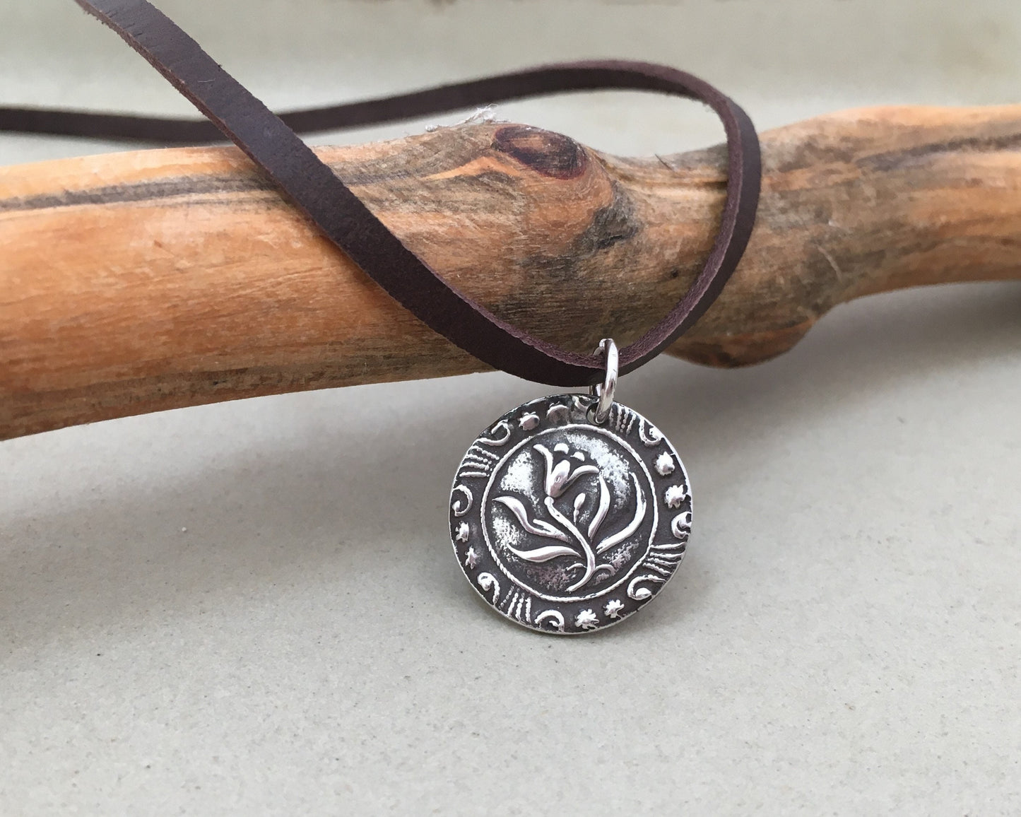 Silver floral medallion on soft leather lace
