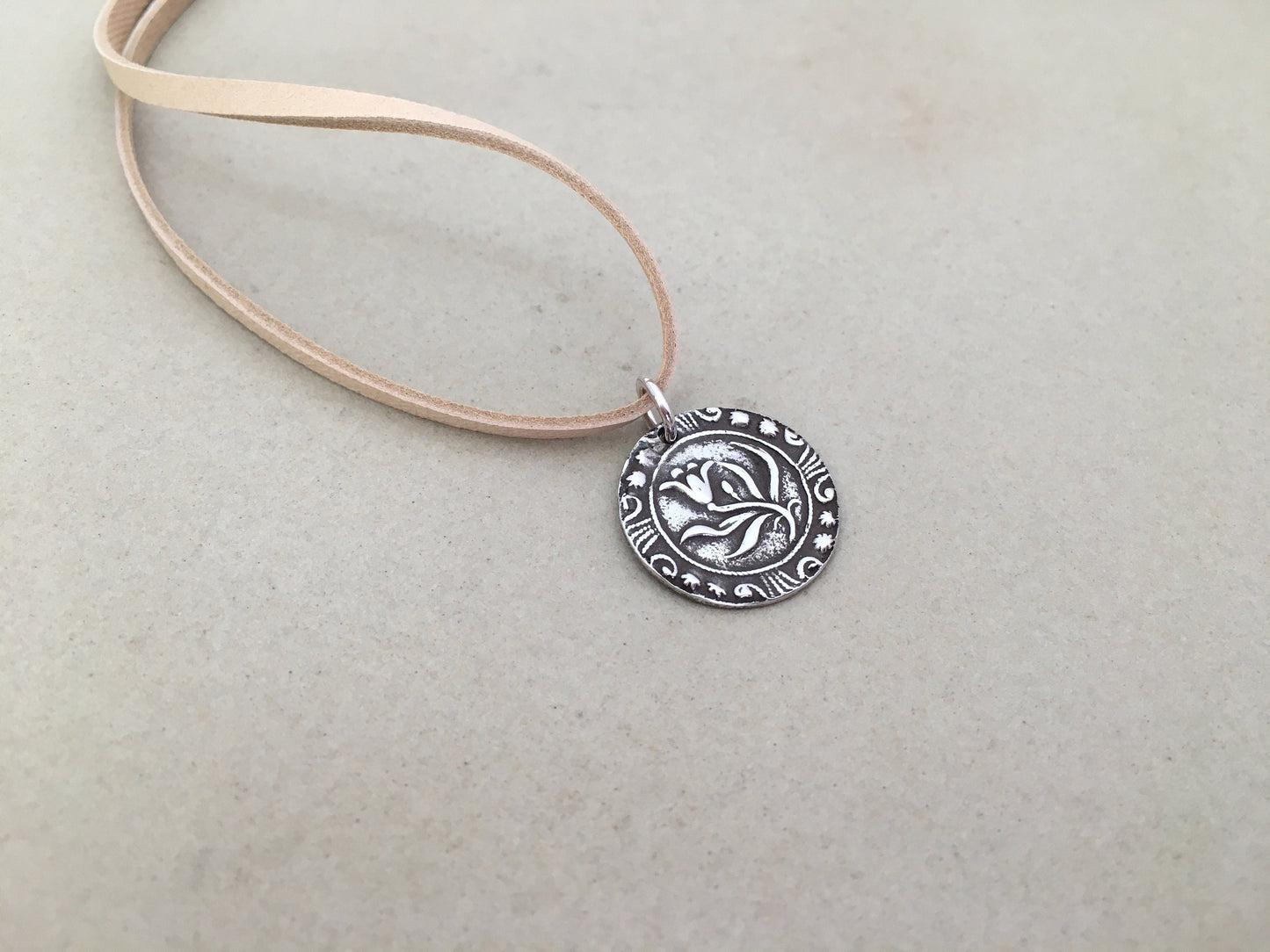Silver floral medallion on soft leather lace