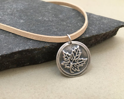 Silver maple leaf pendant on leather