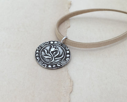 Silver floral medallion on soft leather lace