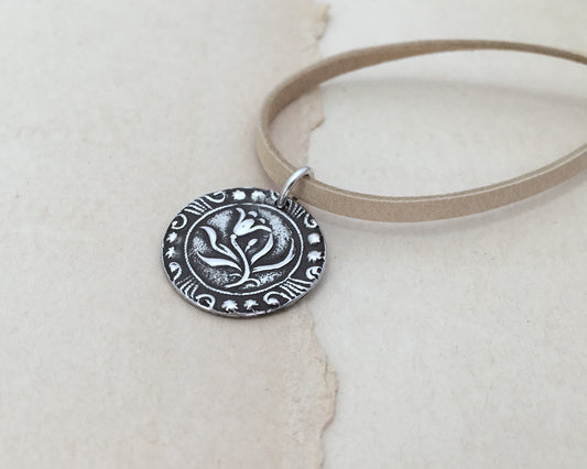 Silver floral medallion on soft leather lace